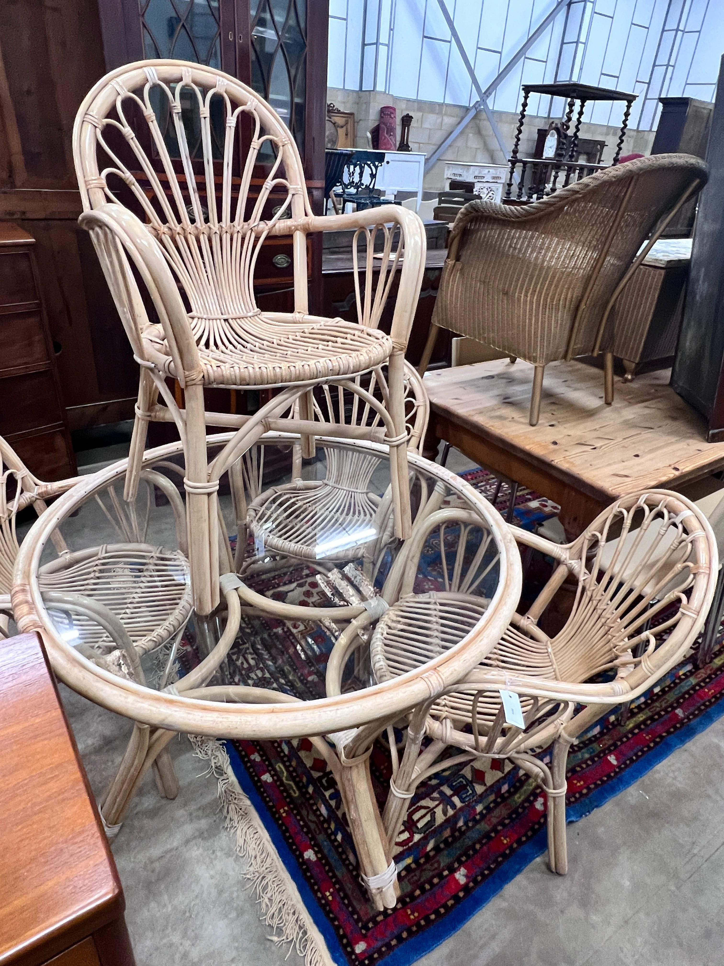 A bamboo circular glass top conservatory table, diameter 106cm, height 73cm and four chairs